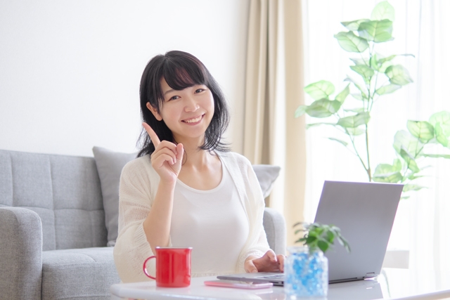 ノートパソコンを開く若い女性　写真