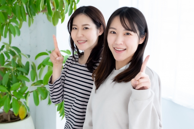 人差し指を指す2人の女性　写真