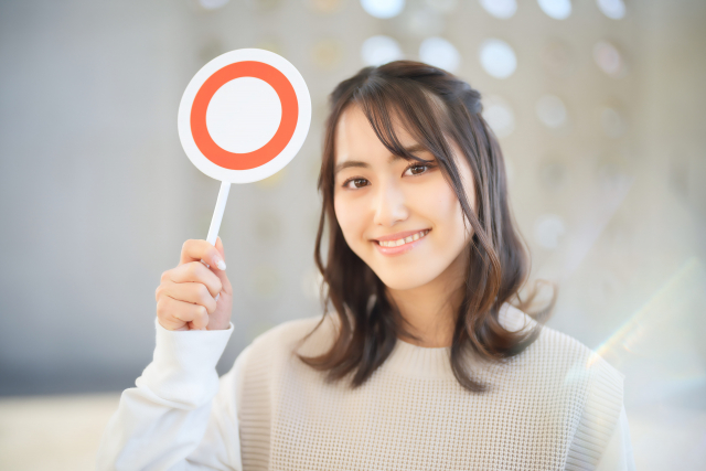 マルのプレートを持つ女性　写真