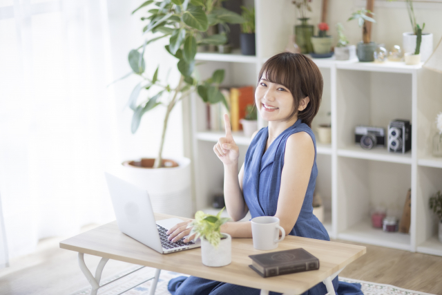 人差し指1本で一番のポーズをする女性　写真